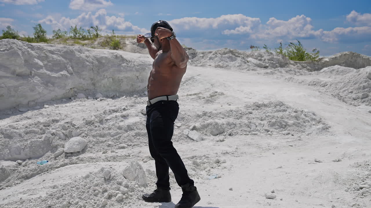 Full length view of the muscular shirtless handsome man posing for camera. Athletic young bodybuilder with naked torso showing his biceps