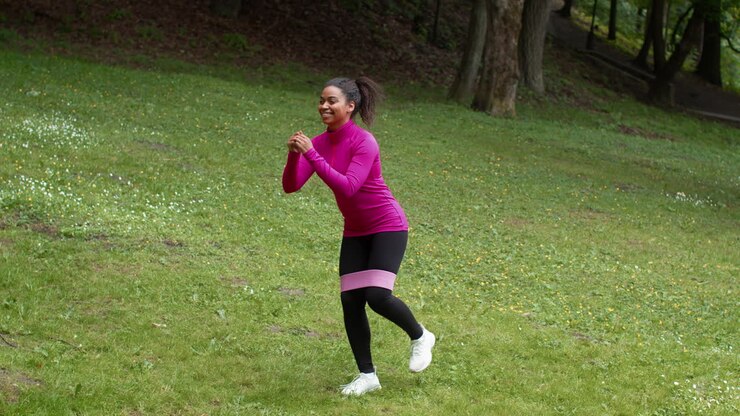 Woman doing leg workout with resistance band in a park