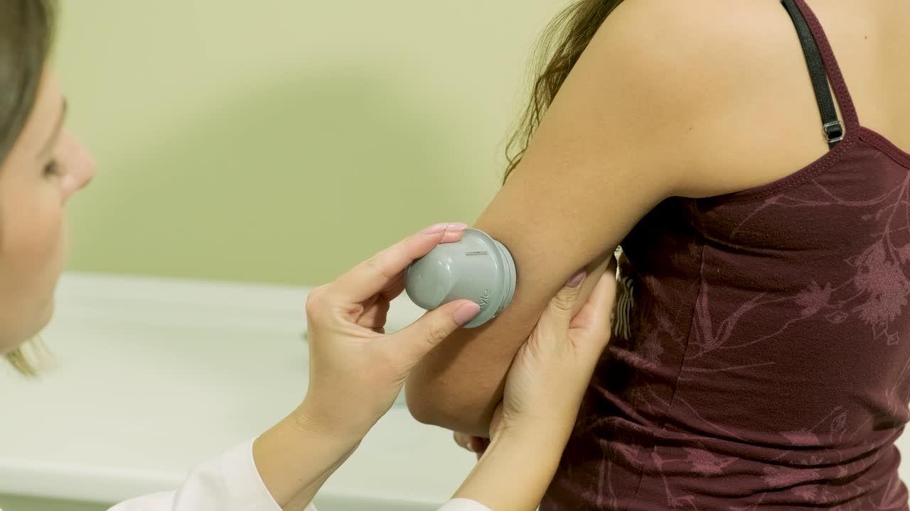 médico con una bomba de insulina conectada en el abdomen del paciente y sosteniendo la bomba de insulina en sus manos. concepto de diabetes.