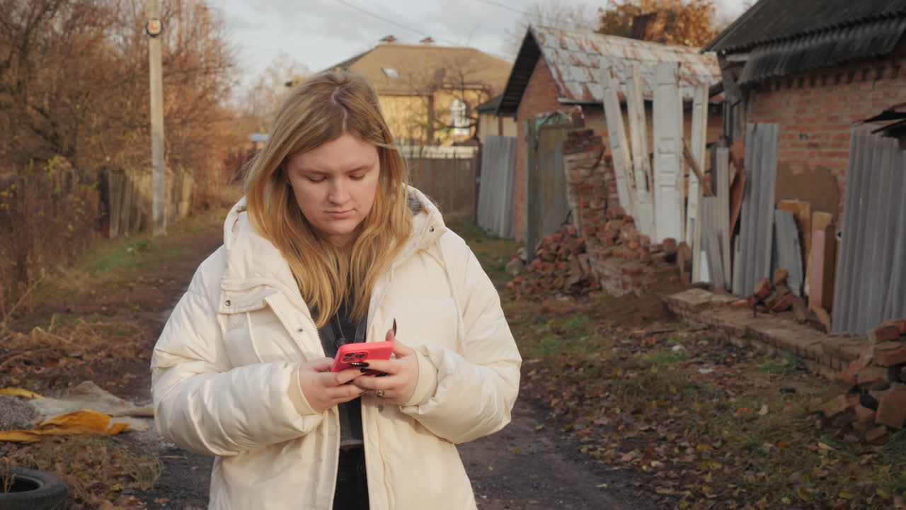 женщина использует телефон на сельской улице