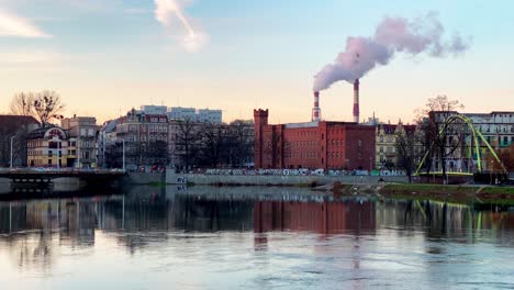 odra river in the old city center with smokestack in wroclaw, poland