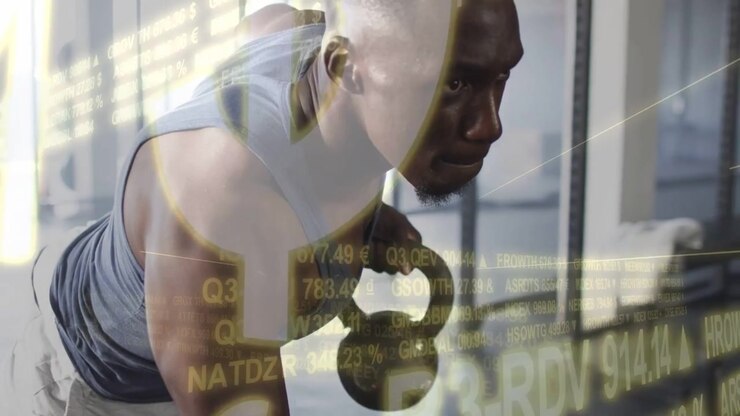 Man in gym reaching kettlebell and pulling row, building core strength as data overlay scrolling