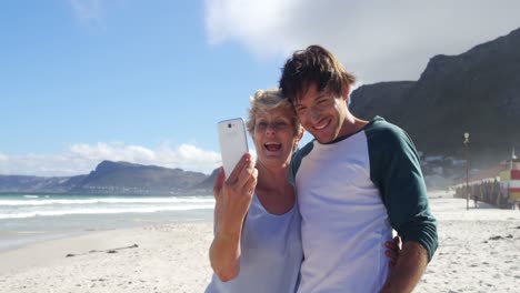 Mother-and-son-taking-selfie-from-mobile-phone-at-beach