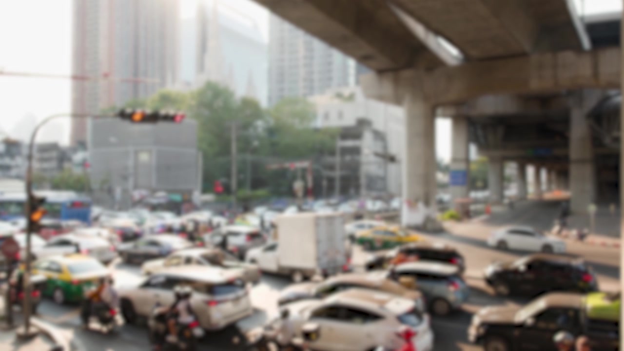 Plan large fixe de la circulation urbaine dense et des motos se déplaçant à travers un carrefour très fréquenté.