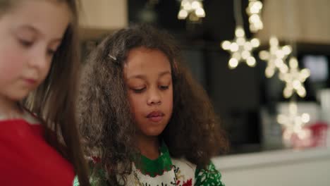 vista inclinada hacia arriba de dos niñas decorando galletas de navidad