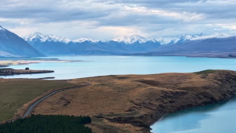 timelapse of clouds passing above snowy mountain range at lake tekapo, new zealand aerial view