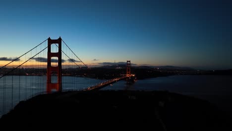 una vista aérea que se eleva desde la cresta de la batería revela el puente de la puerta de oro al amanecer