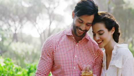 Couple-using-mobile-phone-while-having-glass-of-drink