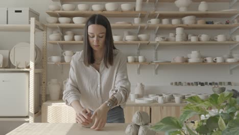 a female ceramicist kneading clay