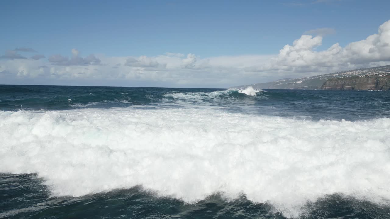 drone volando sobre una gran ola desvaneciéndose en el océano azul, puerto de la cruz, españa