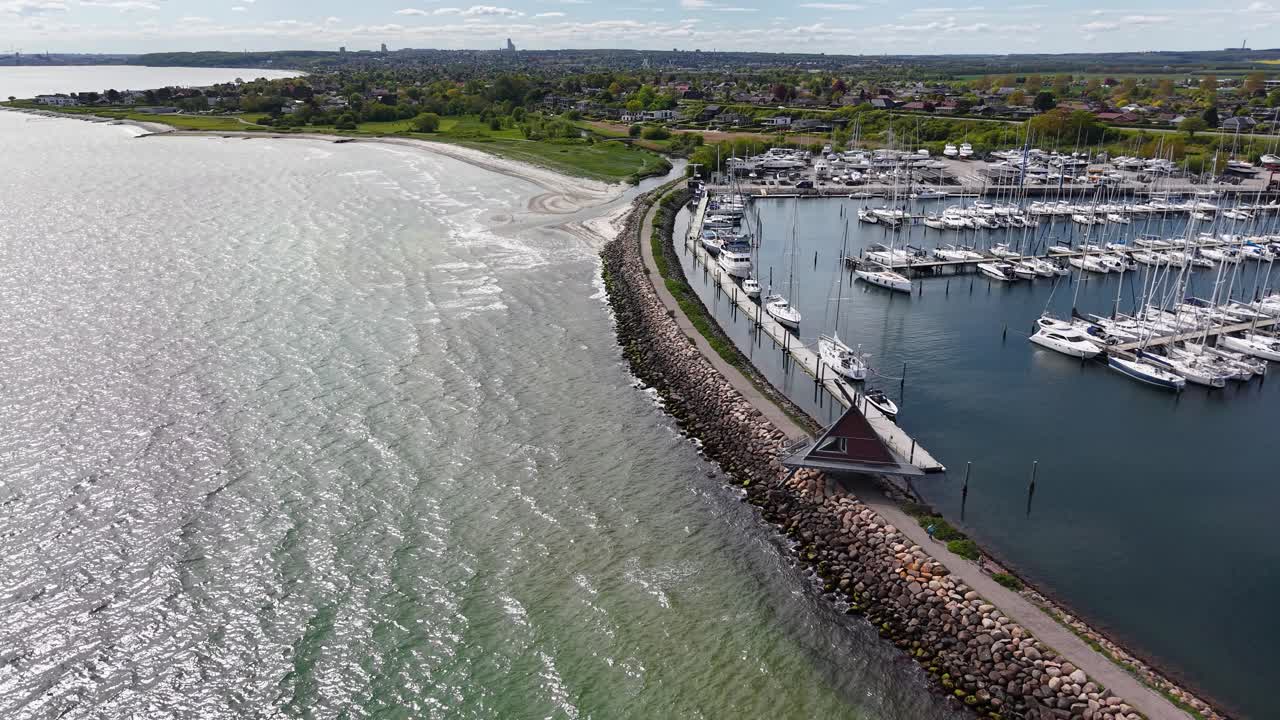 Drone footage captures winding tidal channels weaving through green marshland near Aarhus, Denmark