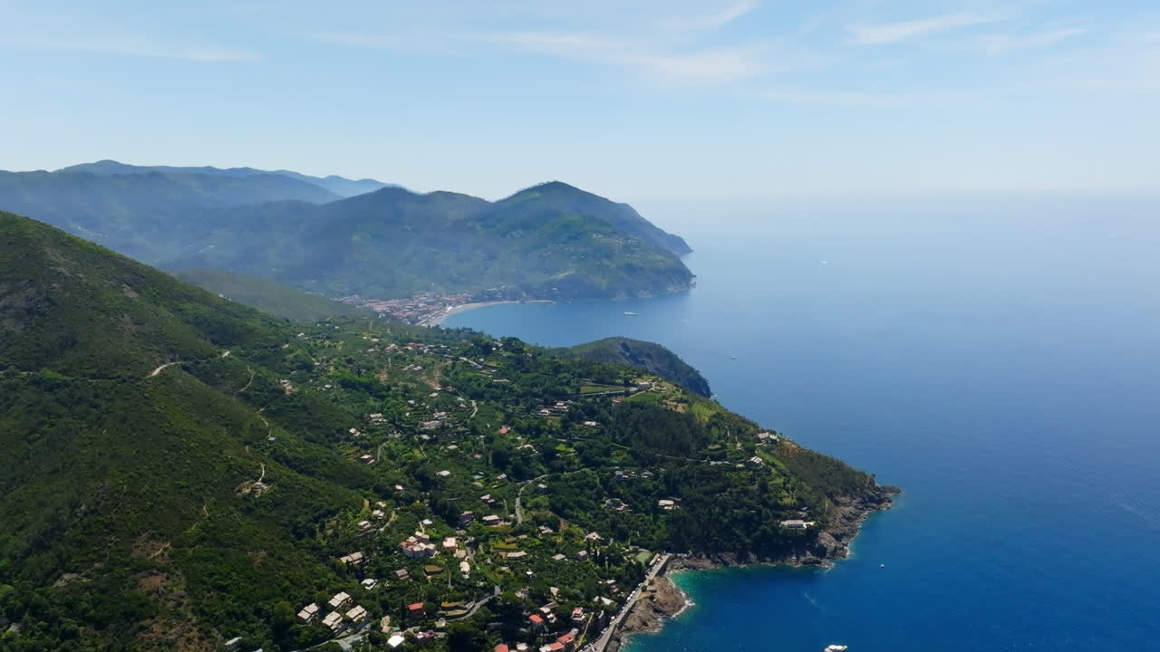 Ripresa aerea panoramica con drone che si alza lungo Bonassola, verso Levanto, Italia, estate