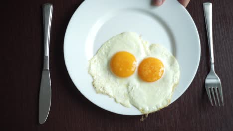 White-plate-with-fried-egg-on-wooden-table.-Serving-breakfast-eggs