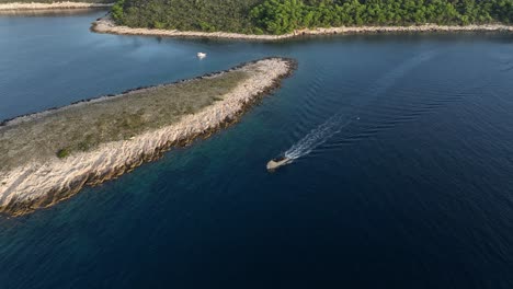 boat sailing near a rocky island in pakleni islands, croatia, aerial view