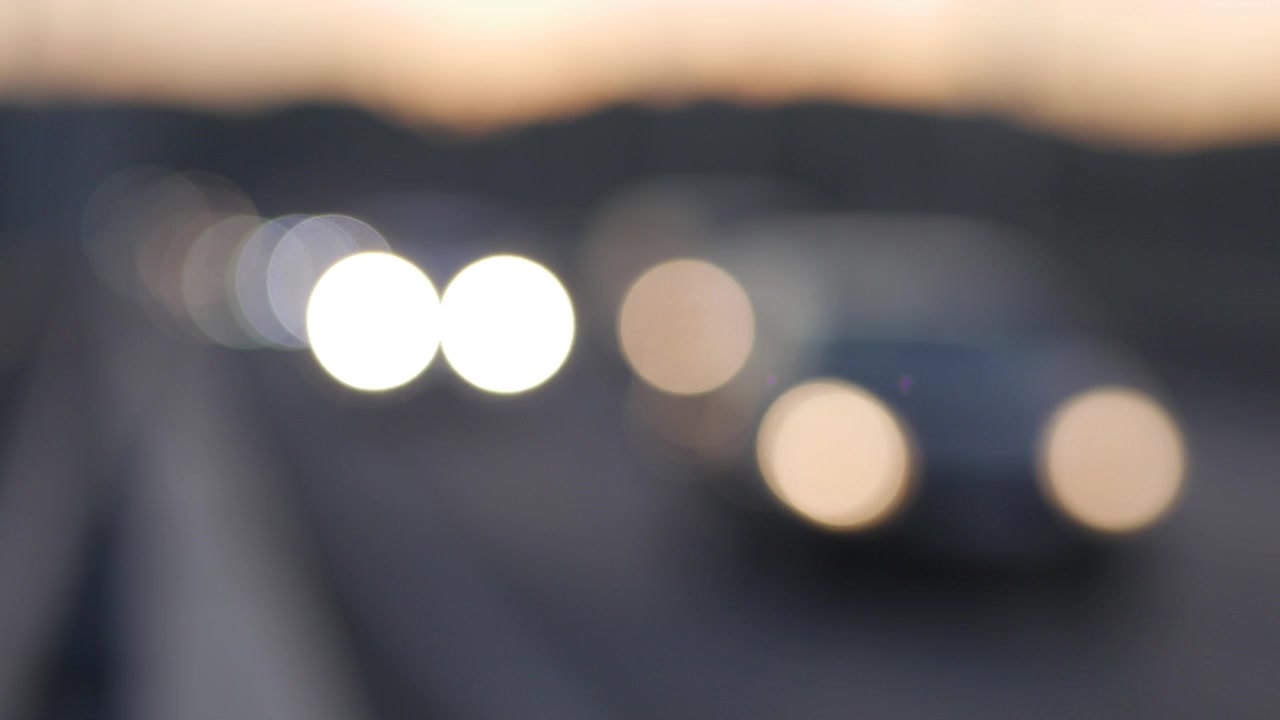 Abstract Bokeh of Moving Car Lights on a Road at Dusk