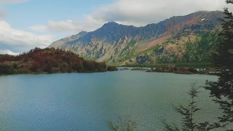 The-drone-flies-out-over-a-lake-with-a-mountain-in-the-background