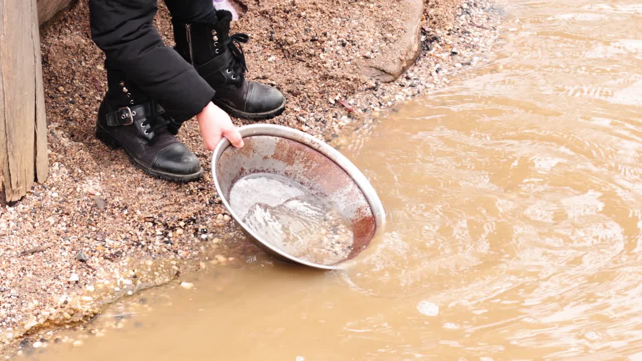 persona buscando oro en aguas fangosas
