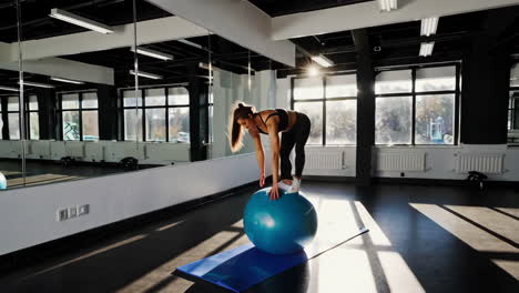 woman practicing balance on exercise ball in gym
