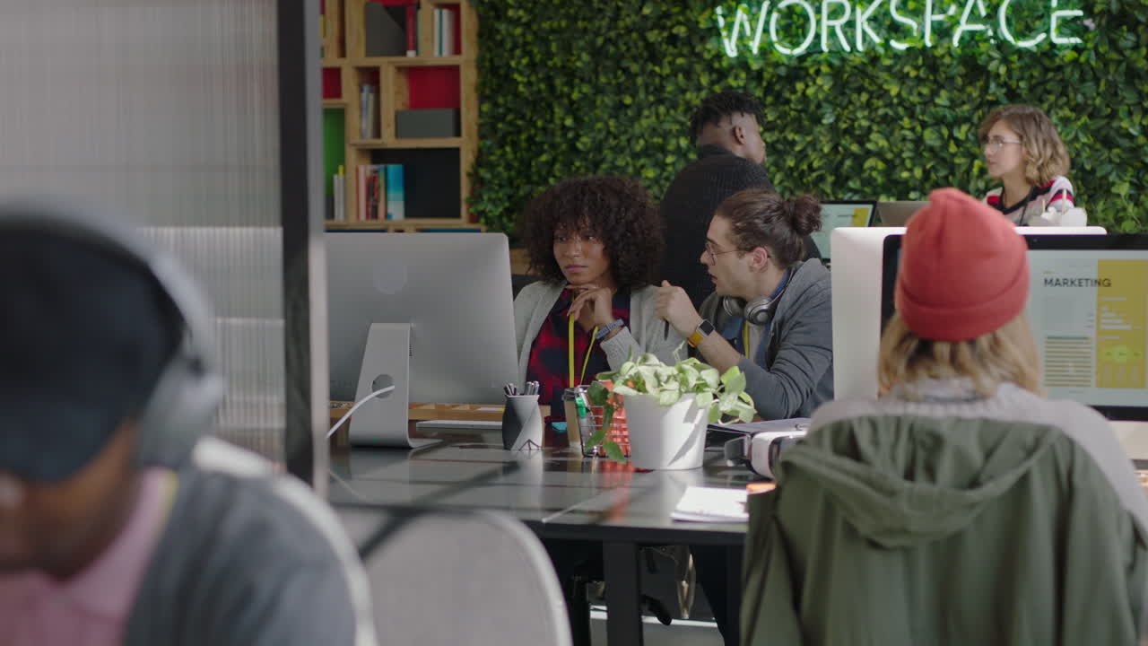 молодые бизнесмены, работающие в офисе стартапа, руководитель кавказской команды, мужчина, указывающий на экран компьютера, помогающий коллеге, делящийся творческими идеями, обучение стажеров, мозговой штурм, обсуждение информации