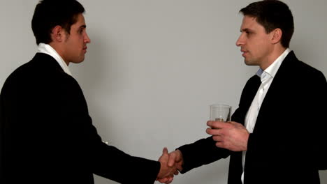 men drinking whiskey shaking hands