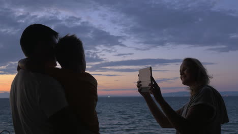 Woman-with-pad-taking-photo-of-husband-with-son