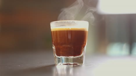 tiros de espresso que se vierten en un vaso con vapor