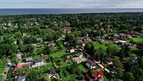 Imágenes-Aéreas-De-Una-Ciudad-Con-Mucha-Vegetación-Y-La-Costa-Visible-Al-Fondo-Cerca