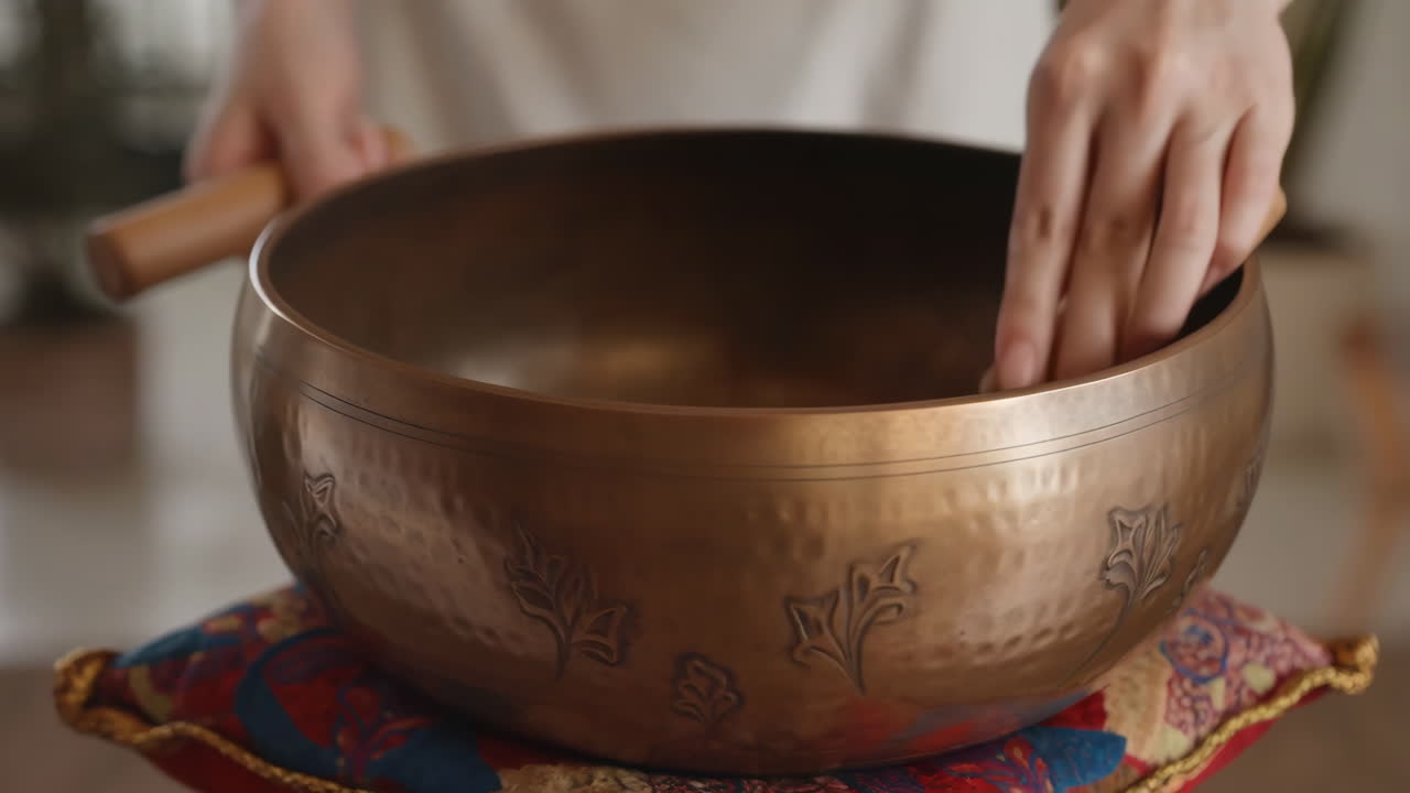 Close-up of Hands Playing a Tibetan Singing Bowl