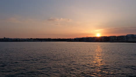 Toma-En-Cámara-Lenta-De-Agua-Que-Refleja-La-Puesta-De-Sol-En-Una-Bahía-En-La-Valeta,-Malta