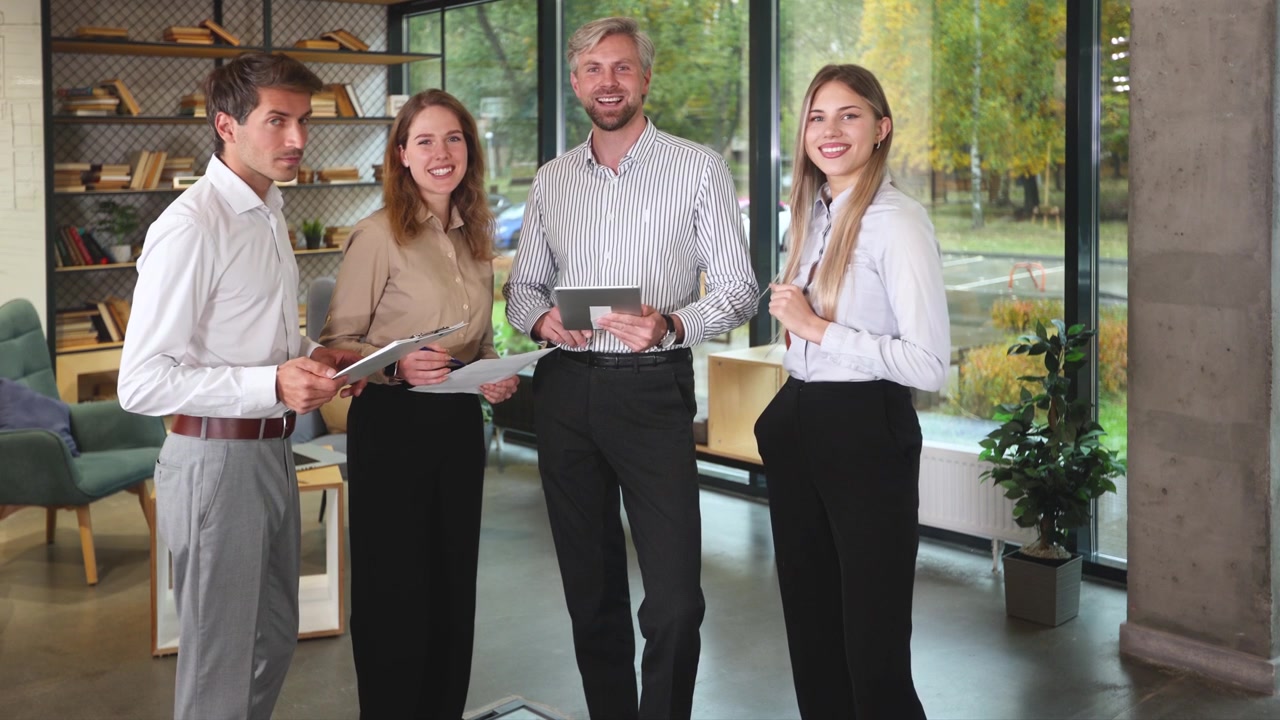 Zakelijk team bespreekt project op tablet en lacht in modern kantoor.