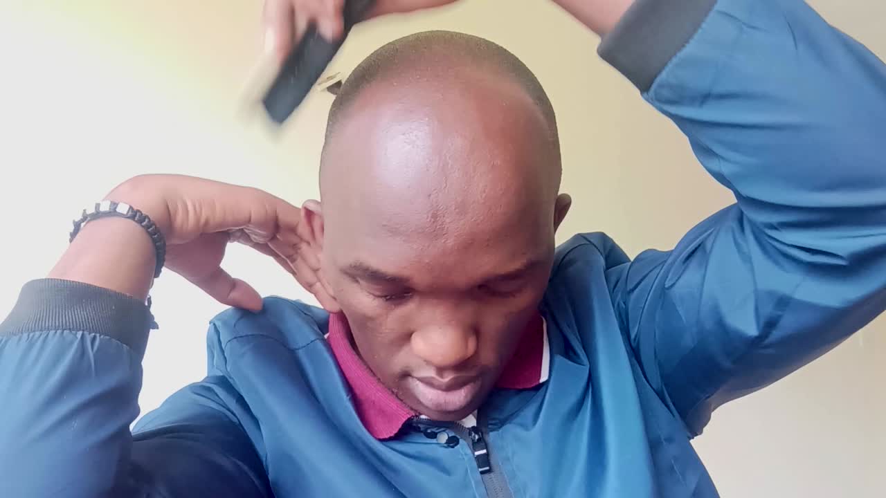 그의 머리를 빗질 하는 젊은 아프리카 남자