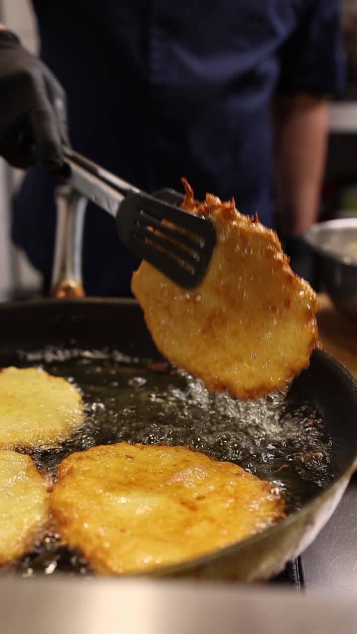 Chef che frigge frittelle di patate dorate nell'olio caldo in padella