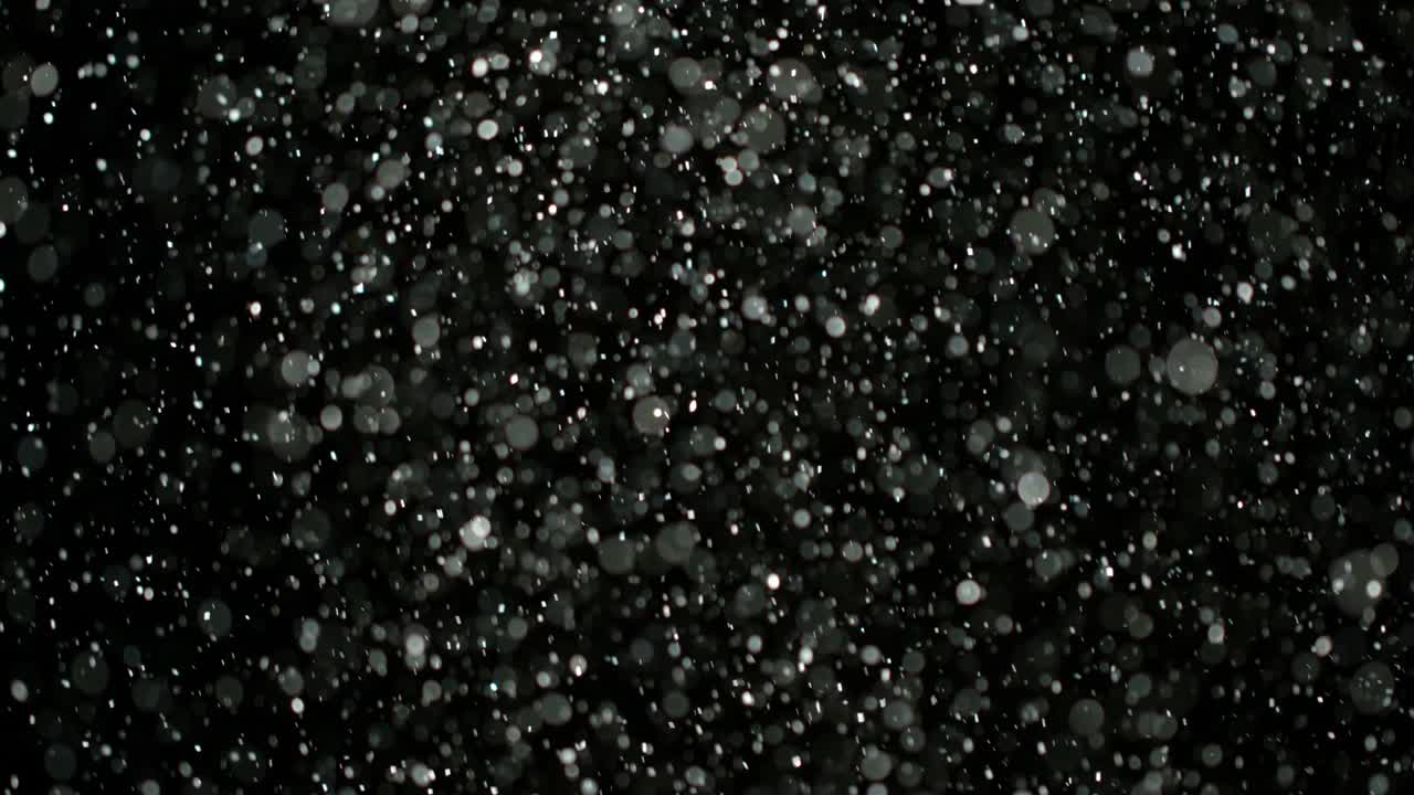 Neve al rallentatore su sfondo nero.
