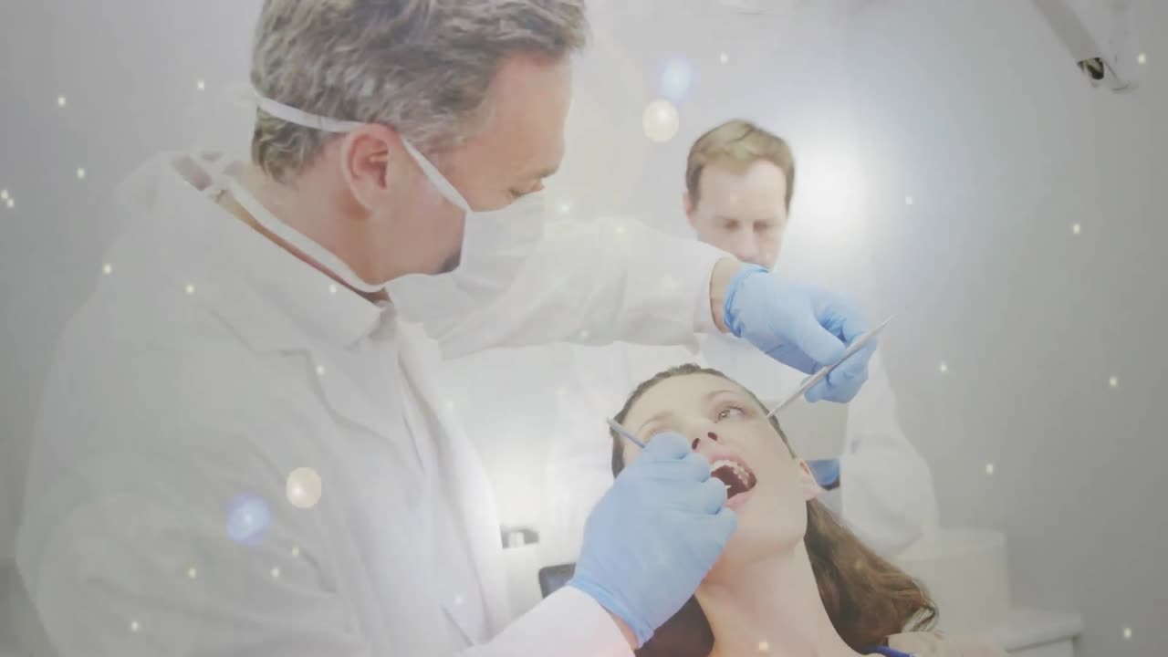 여성 환자를 치료하는 치과의사를 향해 움직이는 빛의 반 ⁇ 이는 반점