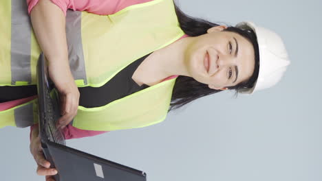 Vertical-video-of-Engineer-holding-laptop-laughing-at-camera.