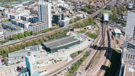 drone shot of uk national rail intercity train leaving tunnel arriving in london