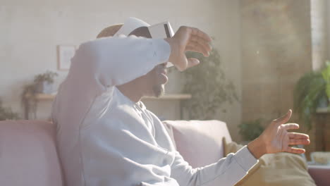 Positive-Black-Man-Using-VR-Glasses-at-Home