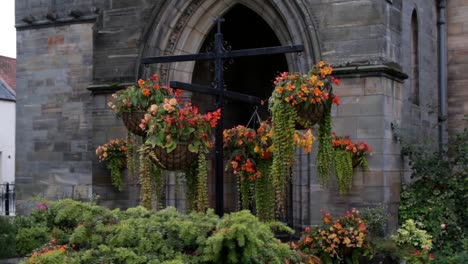 hanging flower bouquet planter in front of church in scotland united kingdom moving in the wind