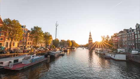 4 k lapso de tiempo de ensueño y mal humor de la hora dorada en el canal de amsterdam con muchos barcos en movimiento y torre, vista panorámica