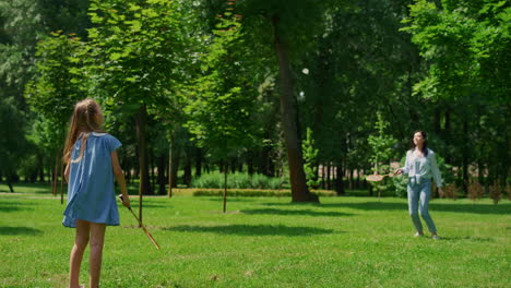 Fröhliches-Mädchen-Spielt-Badminton-Mit-Mutter-Im-Park.-Aktives-Familienruhekonzept.