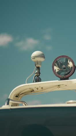 lamp and sound signal device on hardtop of modern motor boat under clear sky closeup. upper parts of sailboat on sunny day. yacht equipment