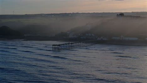 establishing drone shot of saltburn-by-the-sea pier on hazy day uk