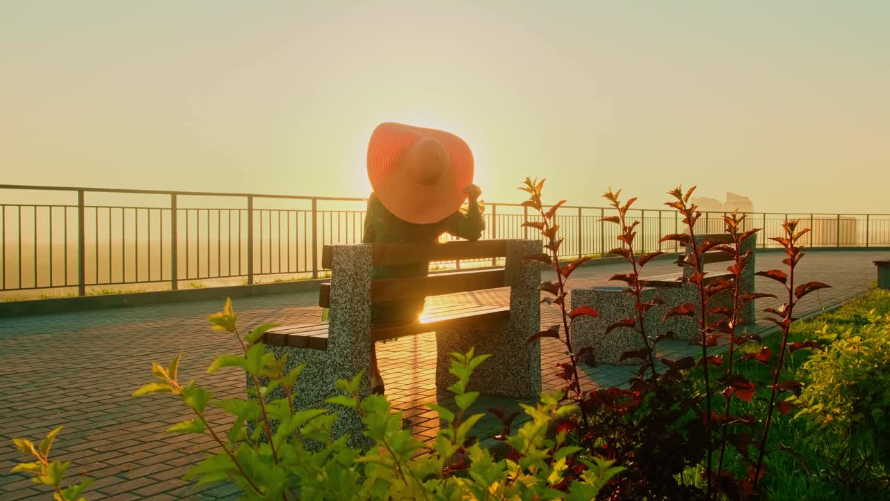 A Serene Morning Scene: A Person Sitting on a Bench at Sunrise Surrounded by Lush Greenery, Enjoying the Peaceful View and Gentle Glow of the Early Light