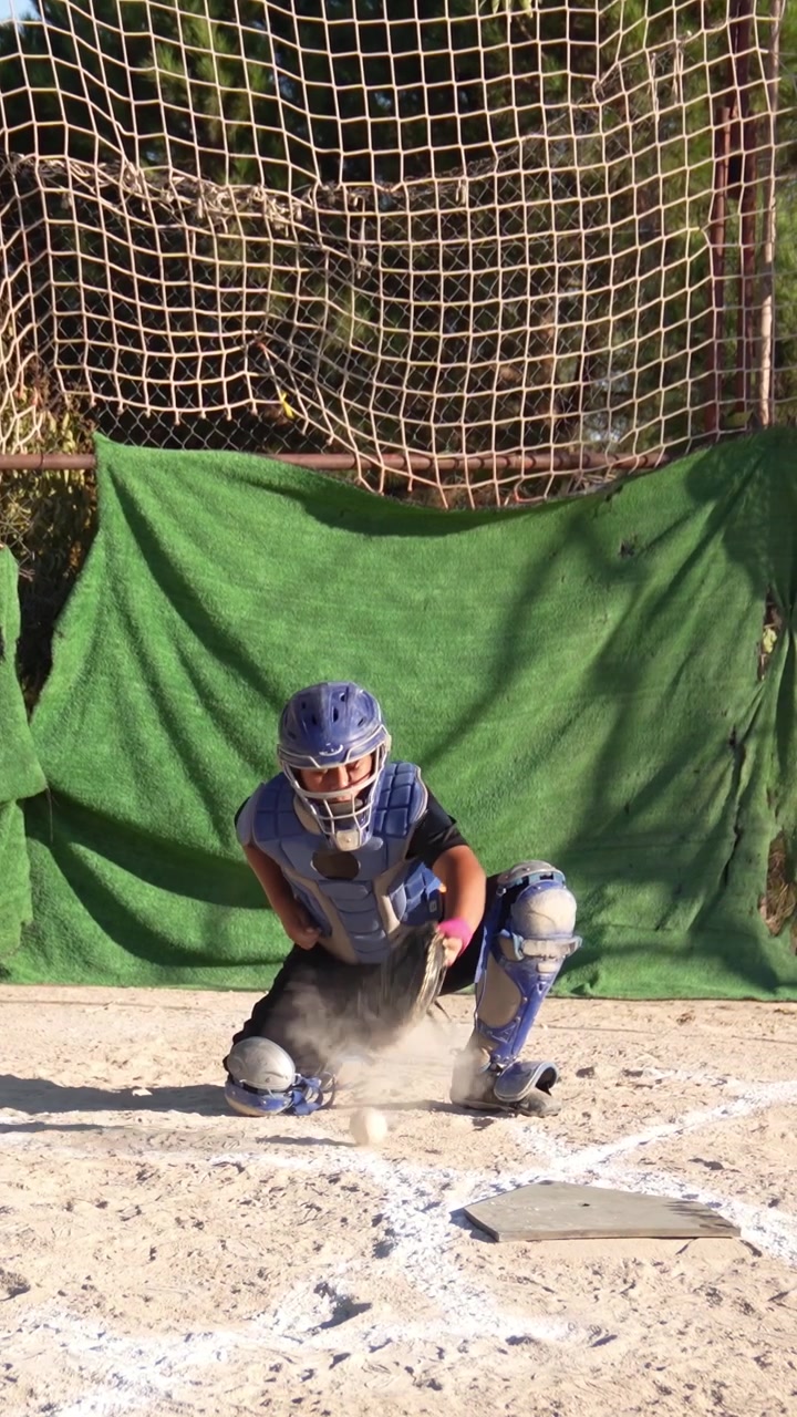 Giovane ricevitore di baseball che si allena a ricevere i lanci a casa base