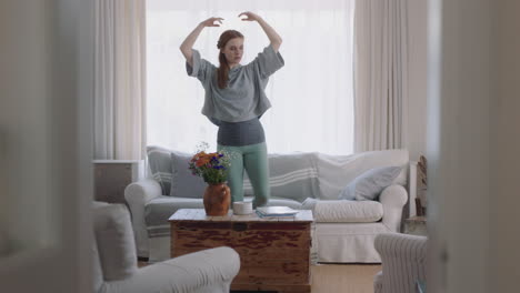 hermosa mujer bailando en casa practicando movimientos de ballet divirtiéndose ensayando en la sala de estar