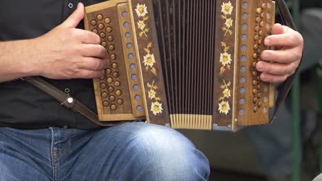 close up shot of male musician playing accordion on street outdoors - slow motion