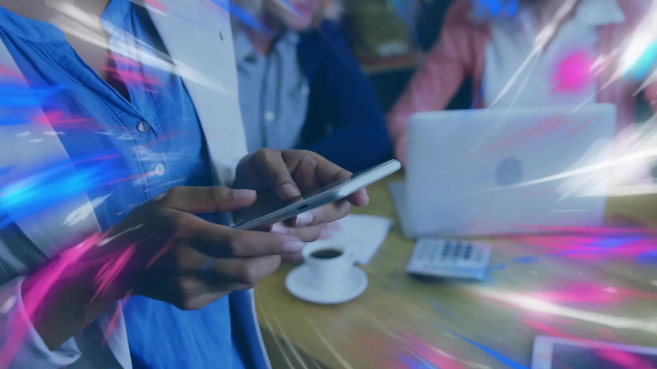 Standing woman scrolling smartphone for project review generating light streaks around colleagues