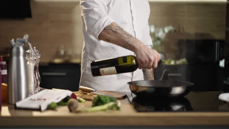 chef pouring wine into a pan while cooking
