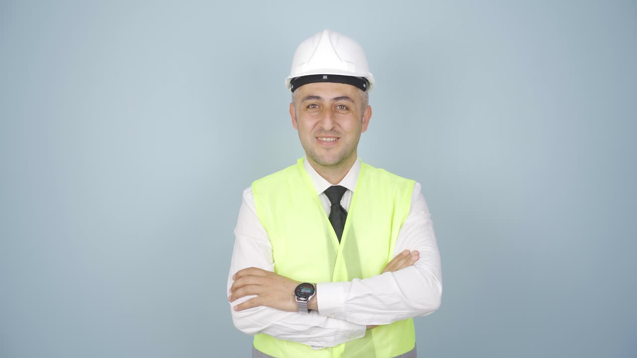 el ingeniero cruza los brazos y se ríe de la cámara.