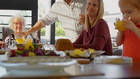 Smiling-mother-looking-at-her-son-while-drinking-juice-4k